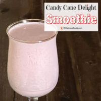 Pink smoothie in a glass on dark background with overlay: Candy Cane Delight Smoothie