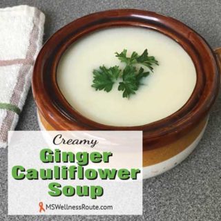 Cauliflower soup in a bowl with overlay: Creamy Ginger Cauliflower Soup