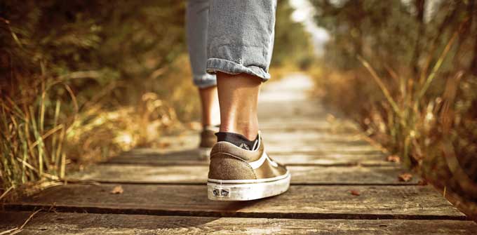 Somebody walking away on a wooden trail.