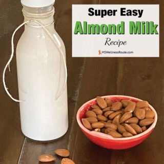 Glass bottle of almond milk with almonds and overlay: Super Easy Almond Milk Recipe