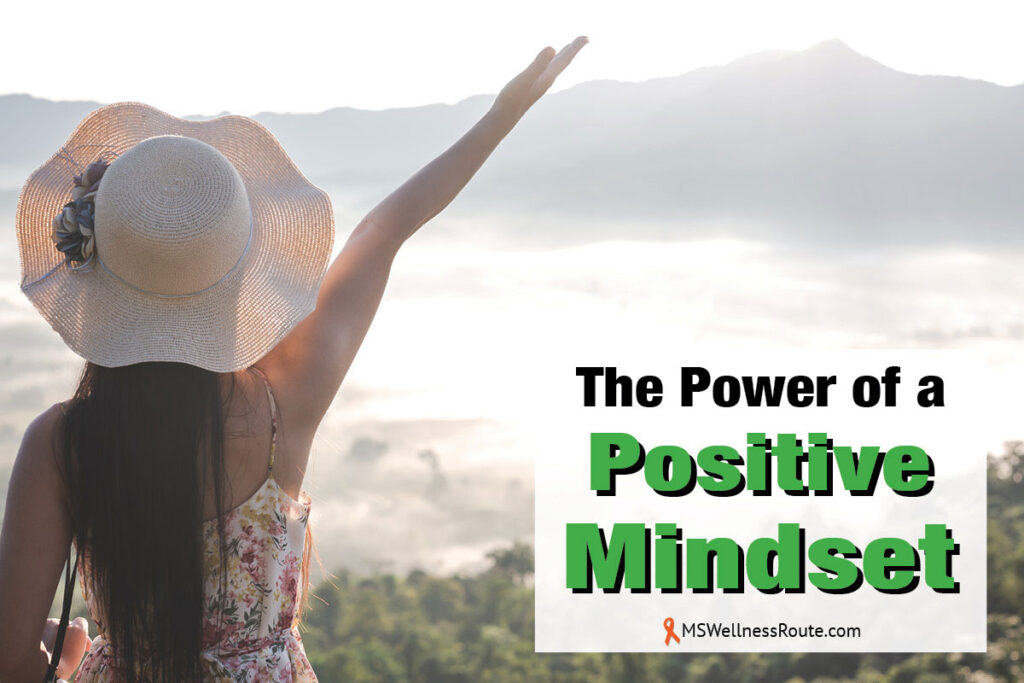 Woman with sunhat and arm in air overlooking lake with overlay: The Power of a Positive Mindset