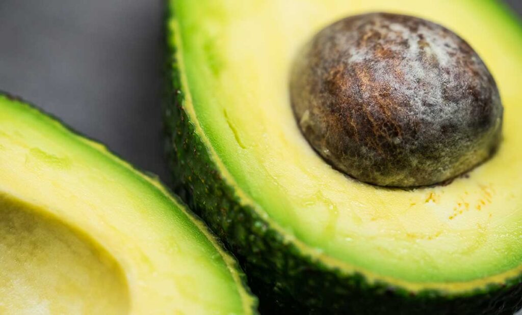 Close up image of an avocado cut in half.