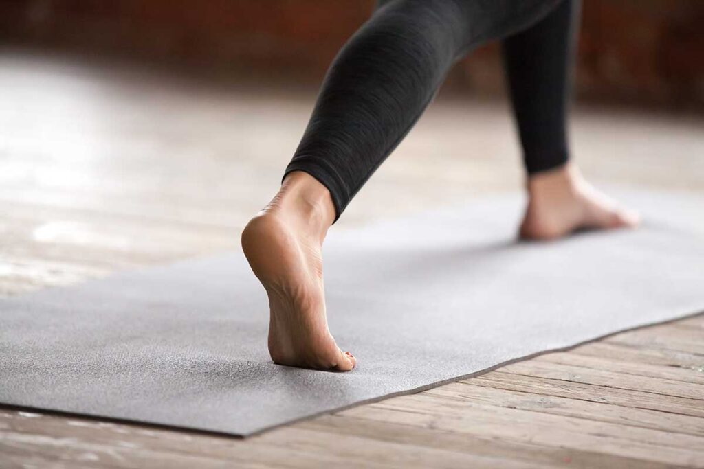 Close up of woman's feet on yoga mat.