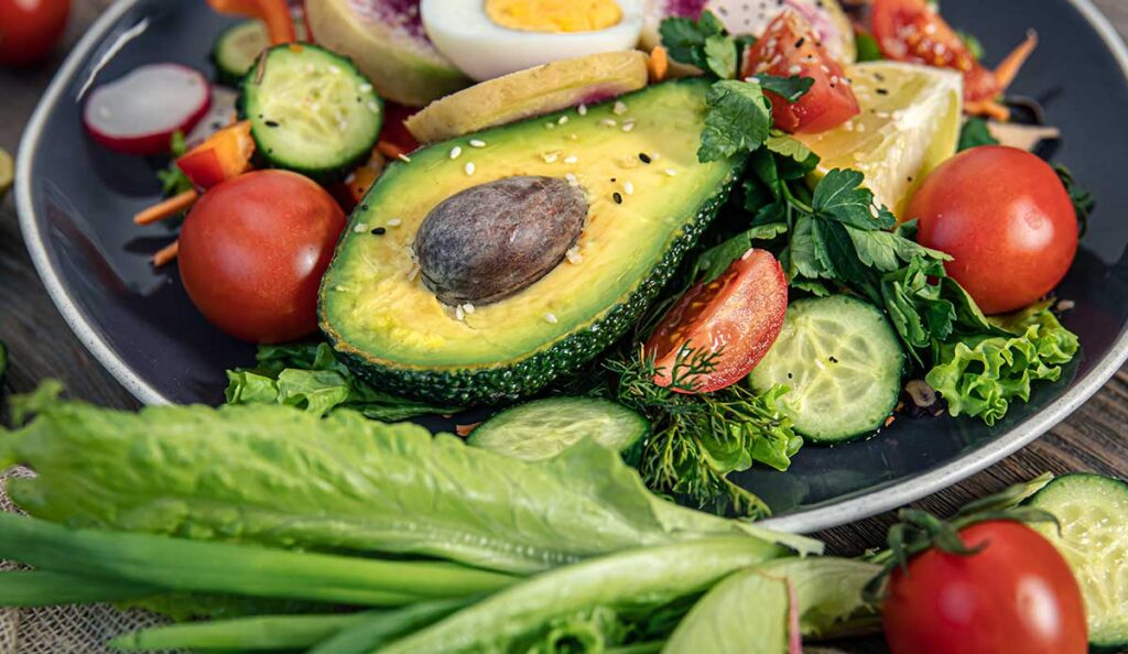 Closeup of vegetable salad with avocado and eggs.
