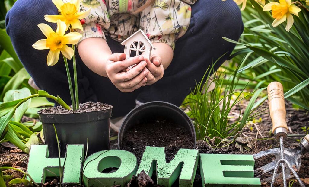 Woman in a flower garden with the word HOME at the bottom.