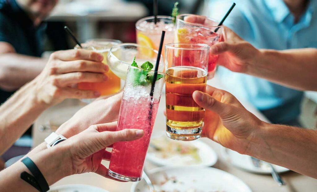 Close up of six people clinking glasses together.