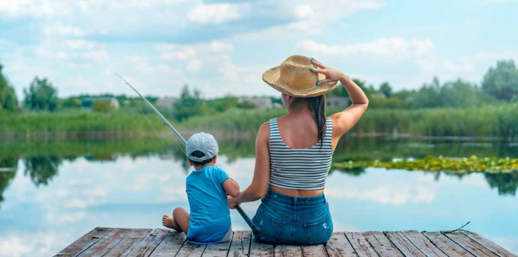 Woman and young child fishing off a dock.