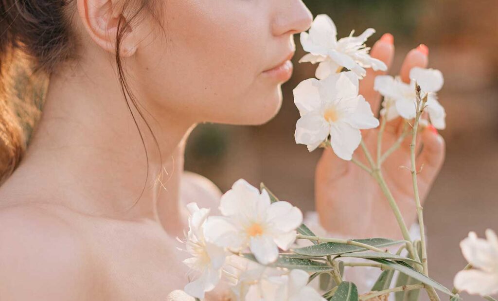 Young woman smelling flowers.