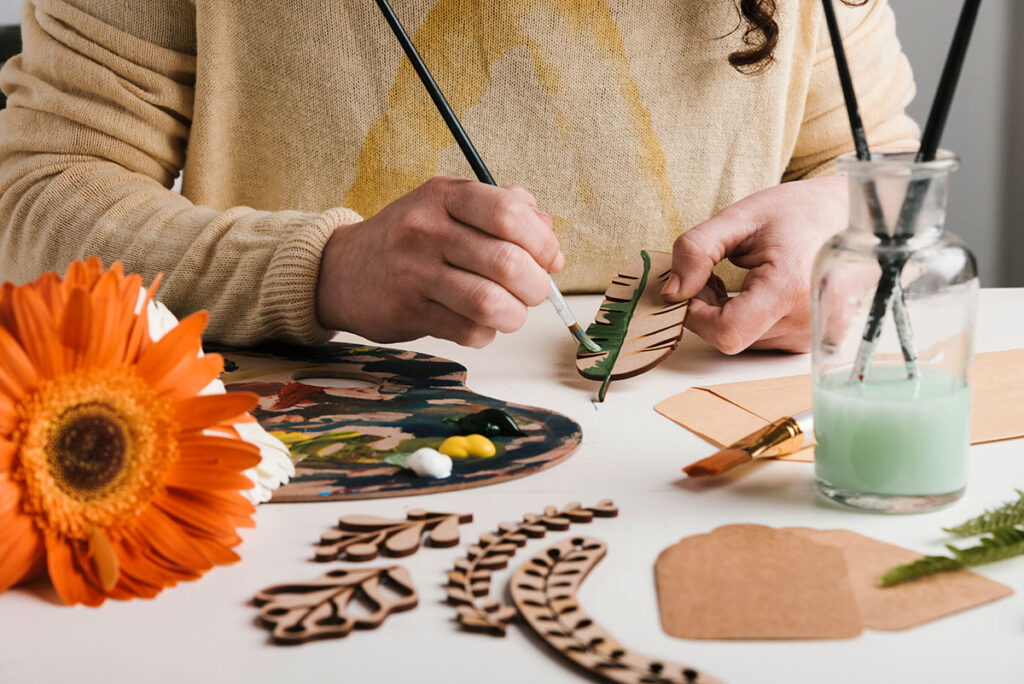 Woman painting wooden wooden crafts.