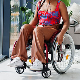 Young disabled woman at home in a wheelchair.